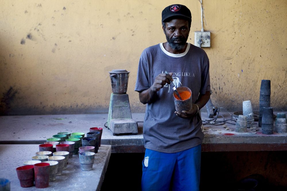 Swazi Candles artisan mixing coloured wax dye in the Malkerns workshop